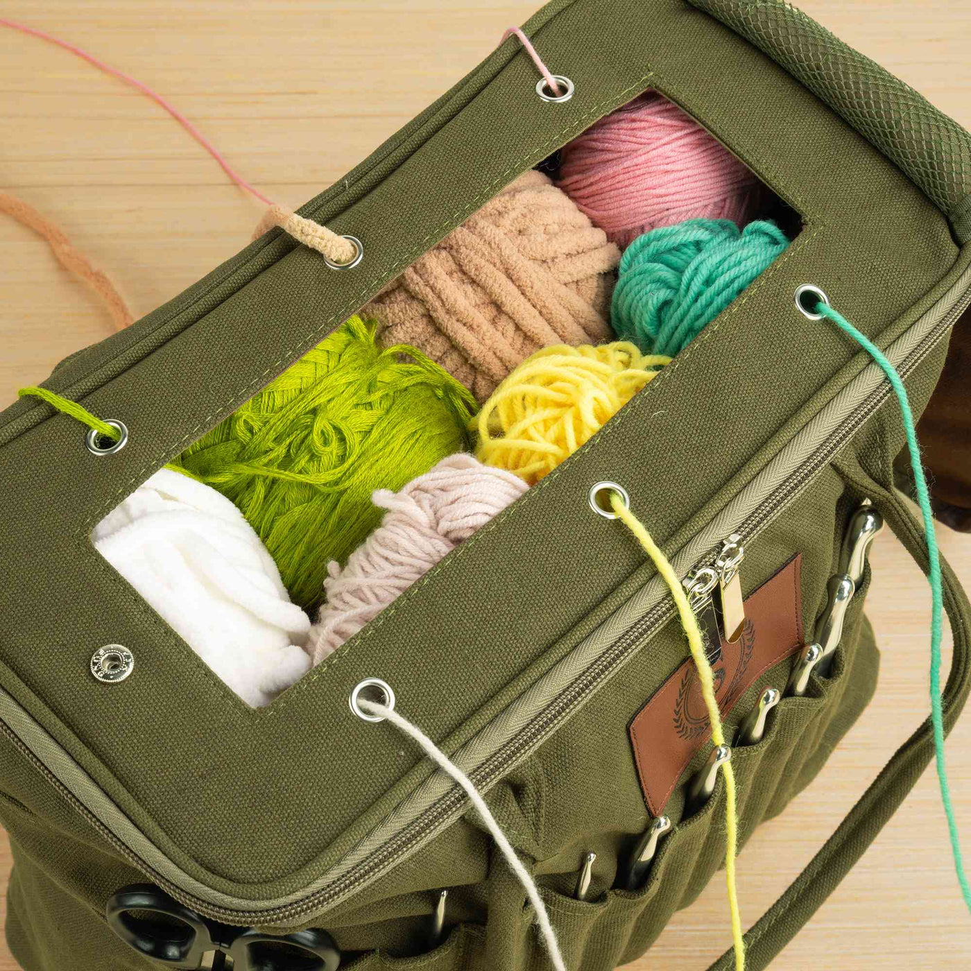 Yarn feeding through separate eyelets in the knitting bag lid